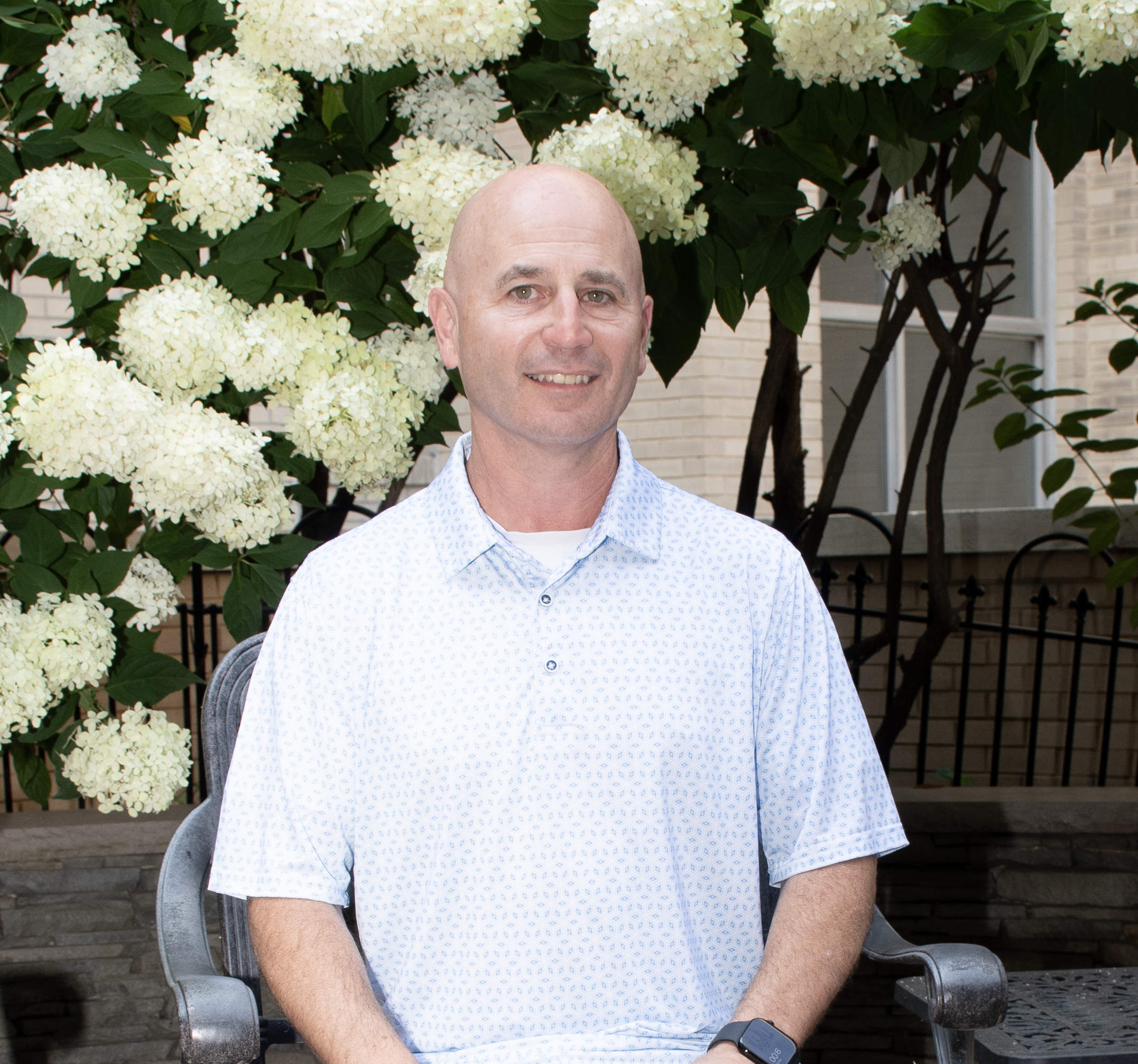 man sits in front of flowering plant