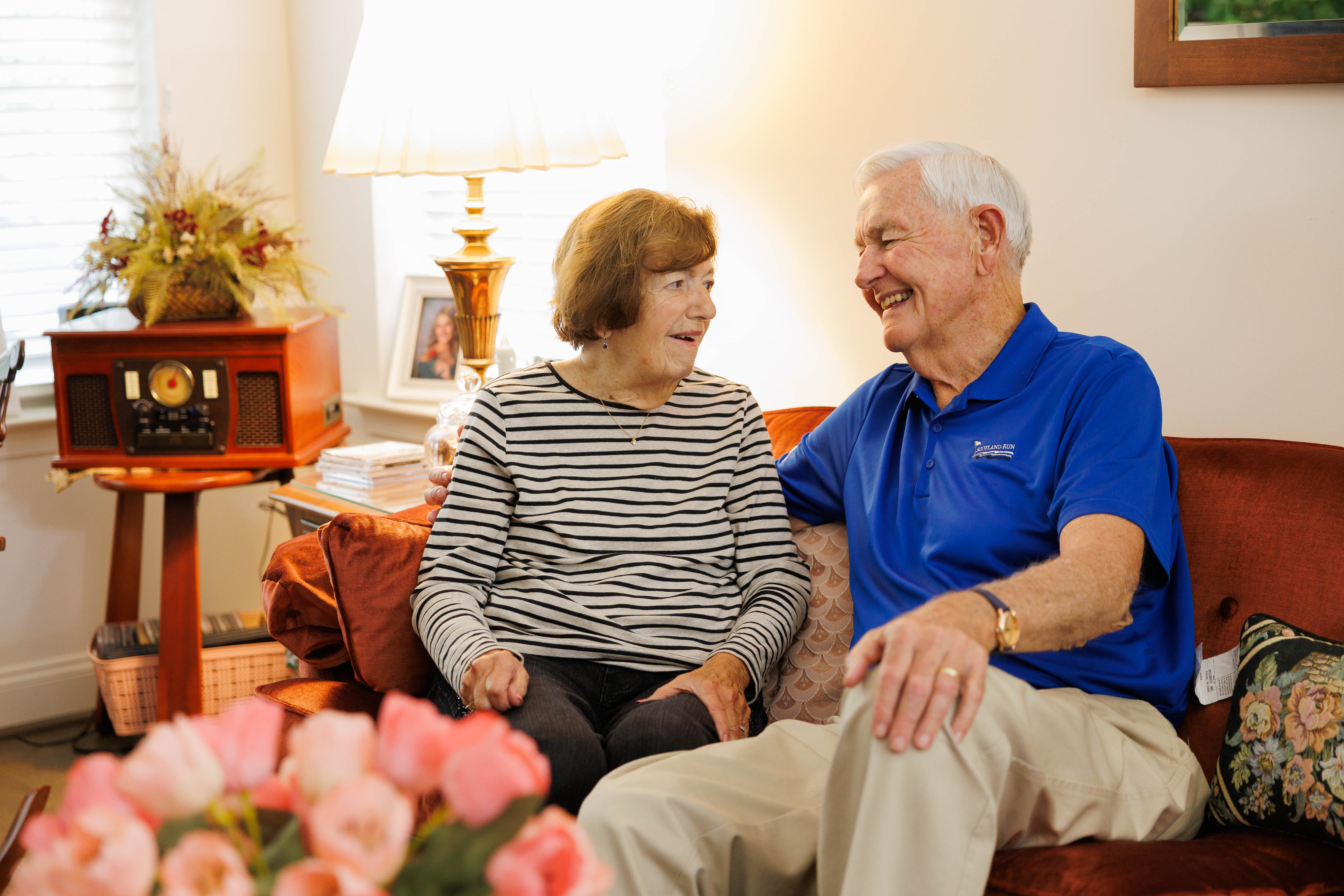 older couple sitting on red couch